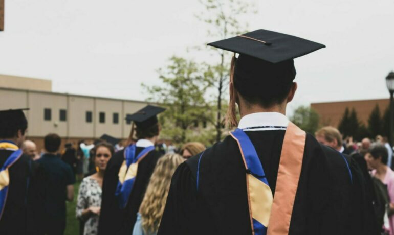 Man facing away from the camera with cap and gown at graduation